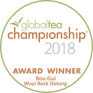 Circular white award badge with green and orange text, featuring the ’global tea championship 2018’’ logo and identifying rou gui wuyi rock oolong as an award winner.