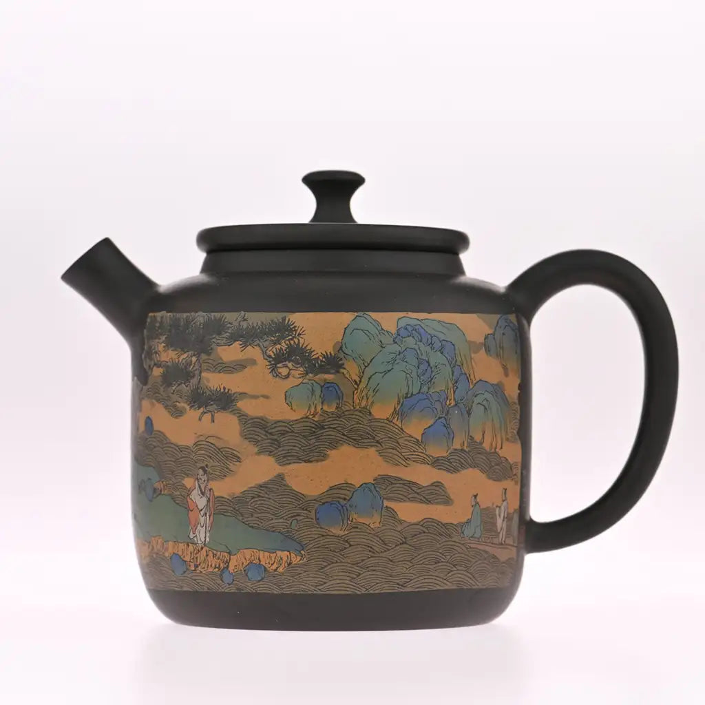 Black ceramic teapot featuring a detailed landscape painting with figures, trees, and mountains in earthy tones of orange, blue, green, and brown.