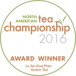 Circular white award badge with green and orange text, featuring ’north american tea championship 2016’’ and identifying lu an gua pian green tea as the award winner.