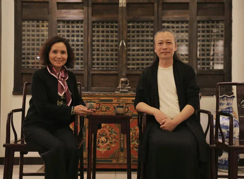The image features a traditional chinese-style wooden table with intricate carvings and a vibrant red painted surface adorned with gold floral patterns.