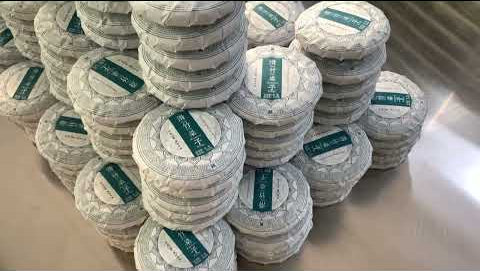 Wrapping Hua Zhu Liang Zi pu'erh tea cakes in the factory, Menghai, Yunnan, China.